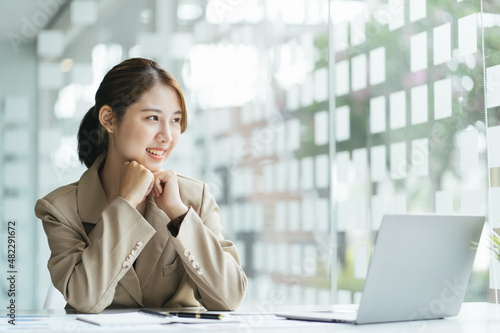 Business woman work process concept. Young woman working university project with generic design laptop. Happy excited woman at home workstation. Blurred background, film effect.