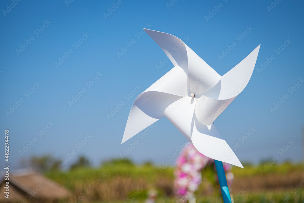 White windmill in the middle of the meadow was blurred with the wind White windmill in the middle of the meadow was blurred with the wind