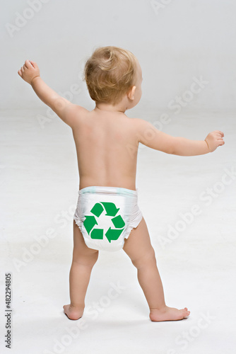 Bebê de fralda com símbolo de reciclagem em pé em fundo branco. (ID: 482294805)