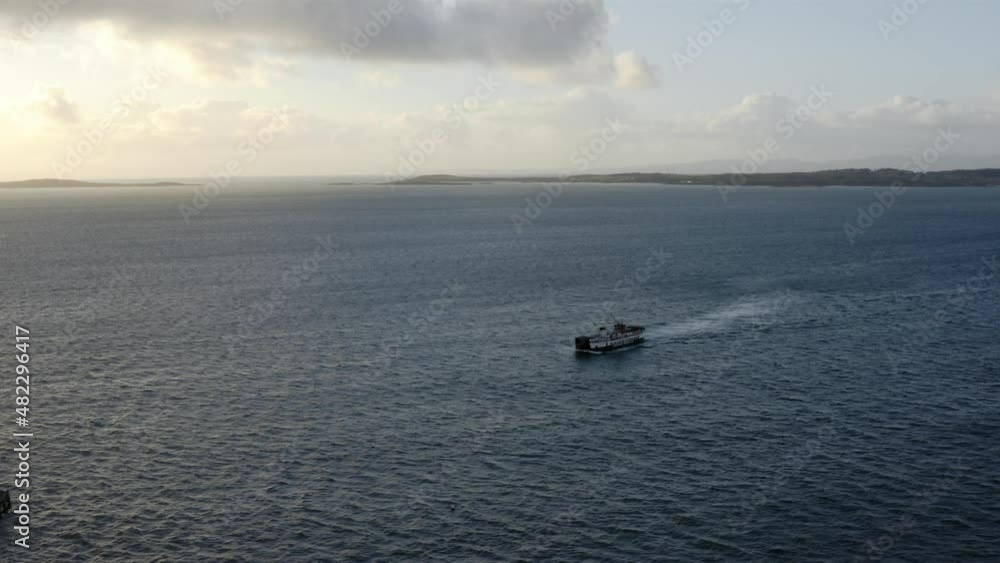 AERIAL - Ferry ship arriving at sunrise to Isle of Gigha, Kintyre, Scotland, forward AERIAL - Ferry ship arriving at sunrise to Isle of Gigha, Kintyre, Scotland, forward