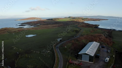 AERIAL - Beautiful horizon, a warehouse and a road, Isle of Gigha, Kintyre, Scotland photo