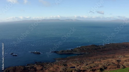 AERIAL - Hills on the horizon, blue sky over the Isle of Gigha, Kintyre, Scotland photo