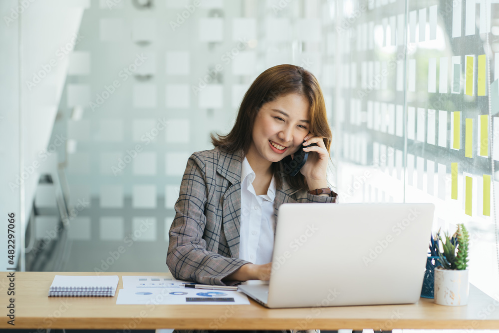 Female professional calling her client working in office. Female professional calling her client working in office.