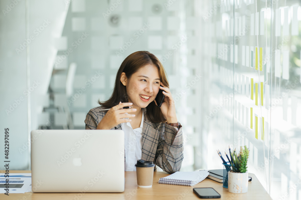 Laughing female entrepreneur talking with a client on her cellphone Laughing female entrepreneur talking with a client on her cellphone