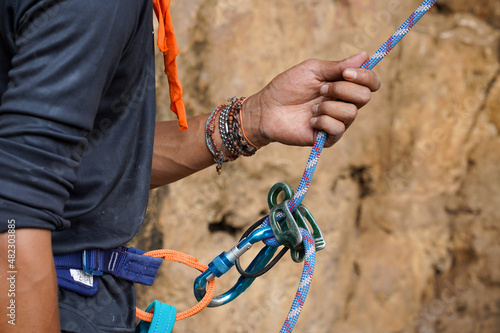 Close up shot a hand holding rope as safety gear on a rock climbing