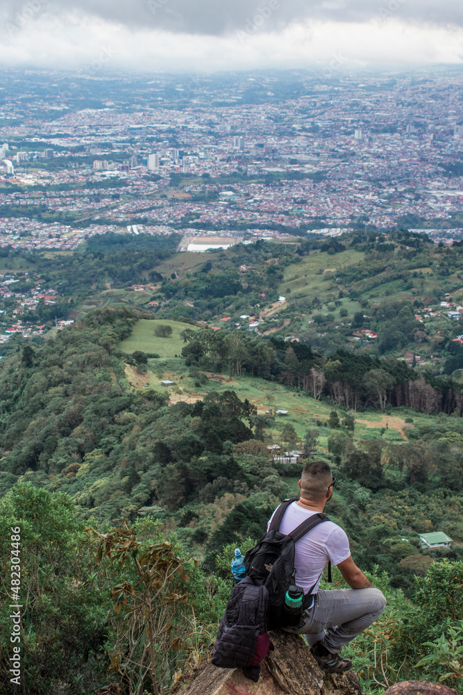 man with backpack contemplating the view to the capital city of San Jose in Costa Rica