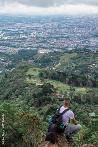 man with backpack contemplating the view to the capital city of San Jose in Costa Rica