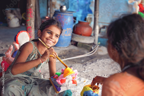 Indian little girls painting the god doll for festival   © V.R.Murralinath
