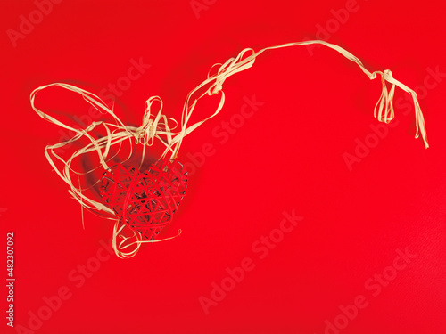 St Valentine's concept as a red heart as if in the nest on the red background with copy space. Flatlay, banner.
