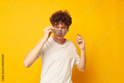 Young curly-haired man in blue glasses white t-shirt fashion modern style isolated background unaltered