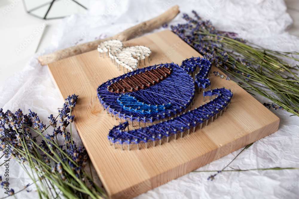 Fototapeta premium Wooden panel in string art technique, thread pattern, handmade