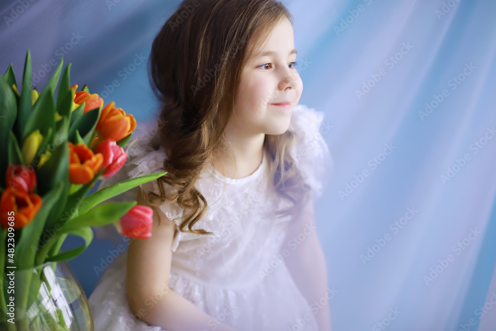 Beautiful girl in white dresses with a magnificent bouquet of the first tulips. International Women's Day. Girl with tulips. Beautiful girl in white dresses with a magnificent bouquet of the first tulips. International Women's Day. Girl with tulips.