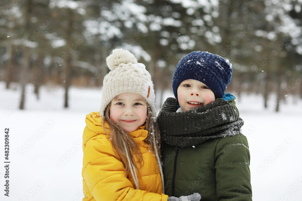 Fototapeta premium Happy family playing and laughing in winter outdoors in the snow. City park winter day.