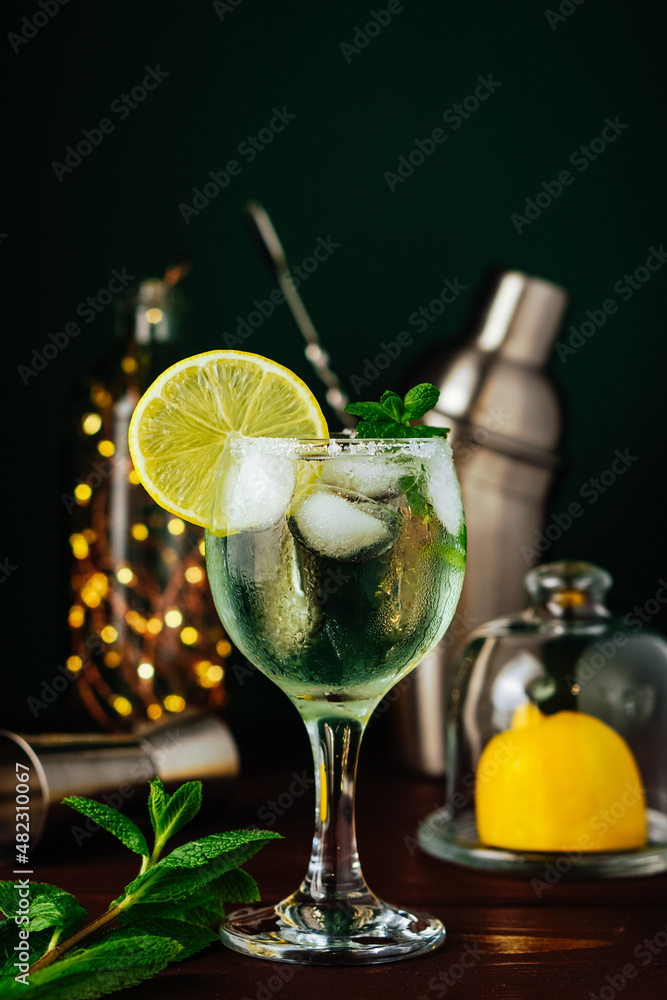 Fresh Mojito cocktail with lemon, mint and ice in jar glass on dark blue background. Summer cocktail