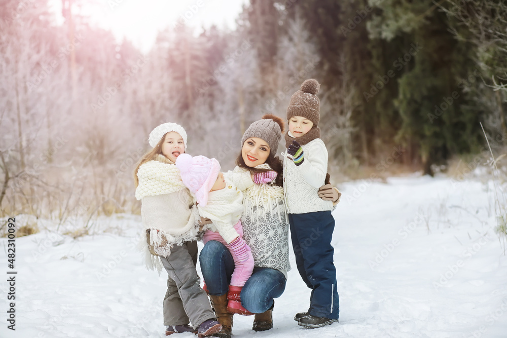 Obraz premium Happy family playing and laughing in winter outdoors in the snow. City park winter day.