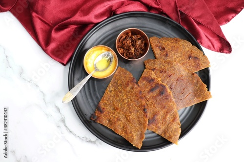 Sweet roti made out of rice flour, jaggery, and ghee. Gud ki roti. gur ki roti, jaggery Bhakri, meethi gud ki roti cooked in banana leaf. Winter food. Copy space. photo