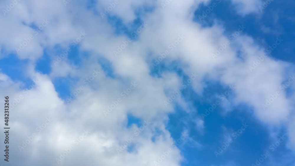 Cloudy Sky background. Beautiful clear blue sky with soft fluffy white clouds in sunny day. Elegant cloudy blue sky texture, wallpaper. Landscape image. Flat puffy shape Cumulus Clouds in daylight