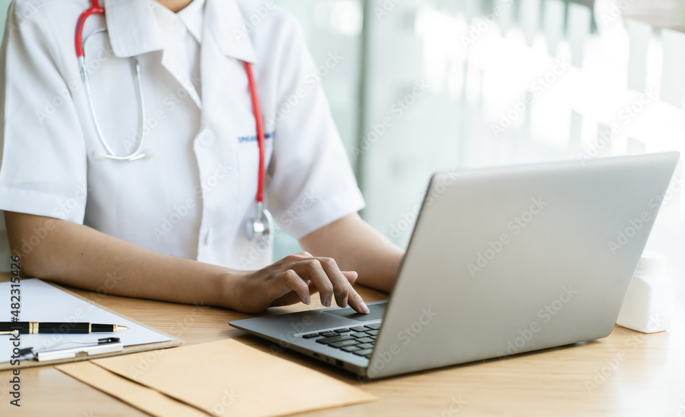 Doctor entering patient notes on a laptop in surgery, Perfect medical service, medicine concept. Doctor entering patient notes on a laptop in surgery, Perfect medical service, medicine concept.