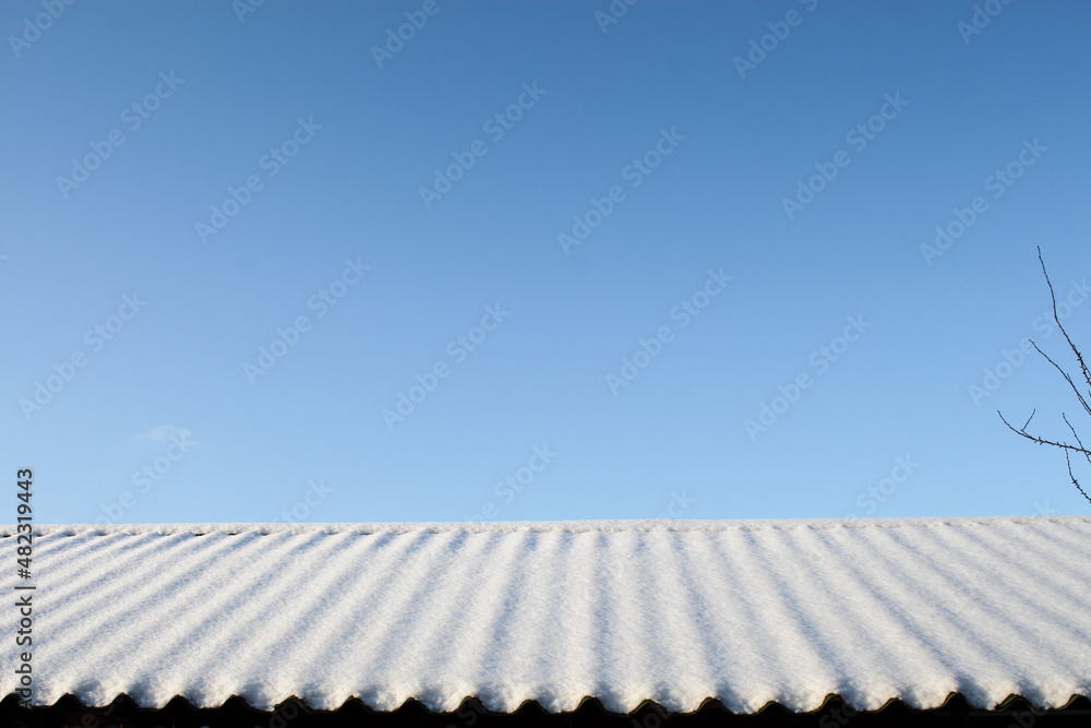 Clear blue skies over a snow-covered roof. Clear blue skies over a snow-covered roof.