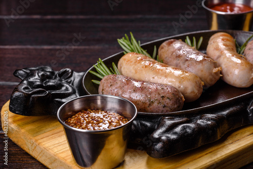 Delicious fresh juicy sausages grill with red sauce in a beautiful cast iron pan