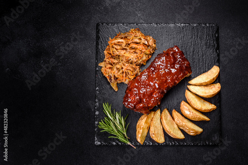 Spicy barbecued pork ribs served with BBQ sauce on chopping board