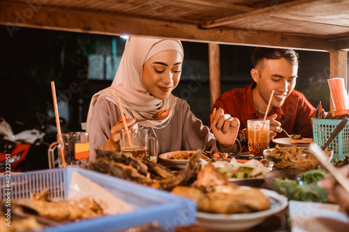 beautiful female muslim and a man having dinner together