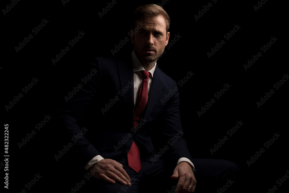 attractive businessman resting on a chair and looking away attractive businessman resting on a chair and looking away