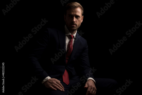 attractive businessman resting on a chair and looking away