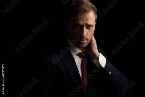 businessman sensually touching his neck and looking deep