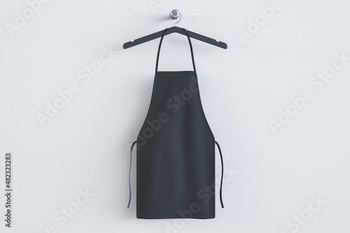 Fényképezés Empty black kitchen apron on hangers
