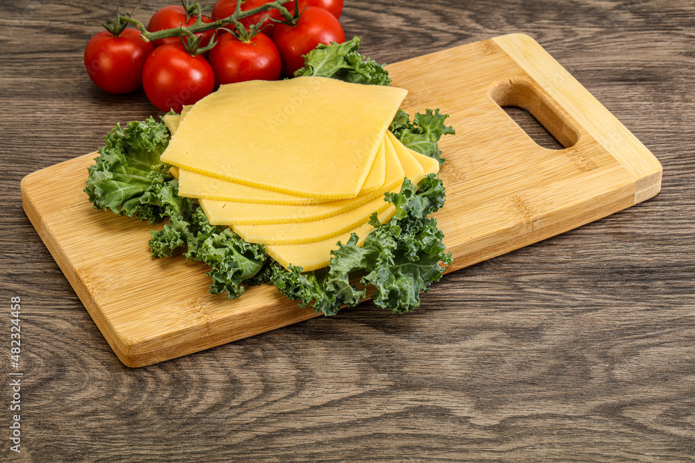 Sliced Gauda cheese over board Sliced Gauda cheese over board