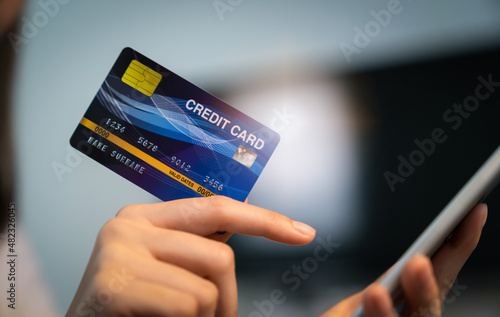 Close up of hand holding credit card with paying online on smartphone in internet store.