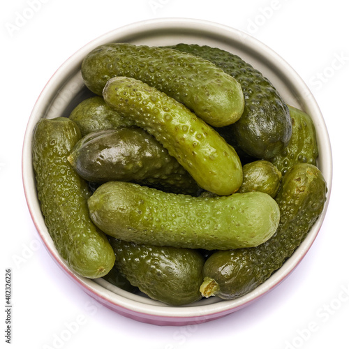 Plate of Tasty canned Whole green cornichons isolated on a white background