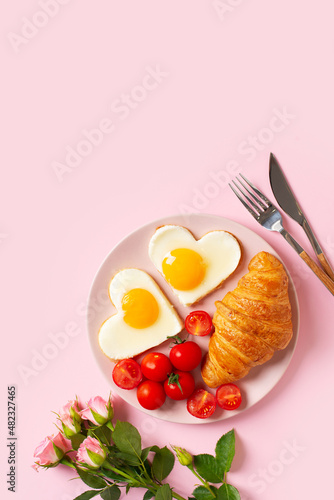 Healthy breakfast with eggs hearts and cup of coffee on pink background