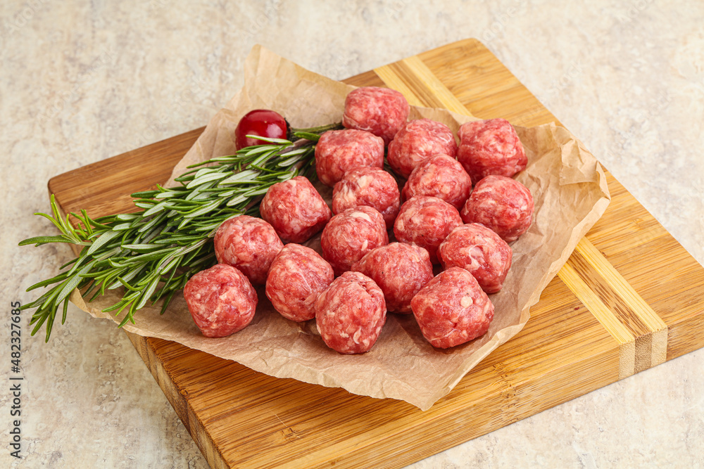 Raw uncooked beef meatballs served rosemary Raw uncooked beef meatballs served rosemary