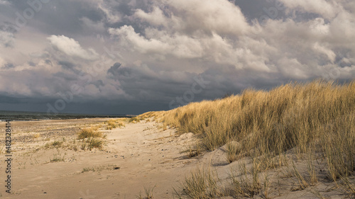 on the beach of the baltic sea with clouds, dunes and beach. Hiking in autumn.