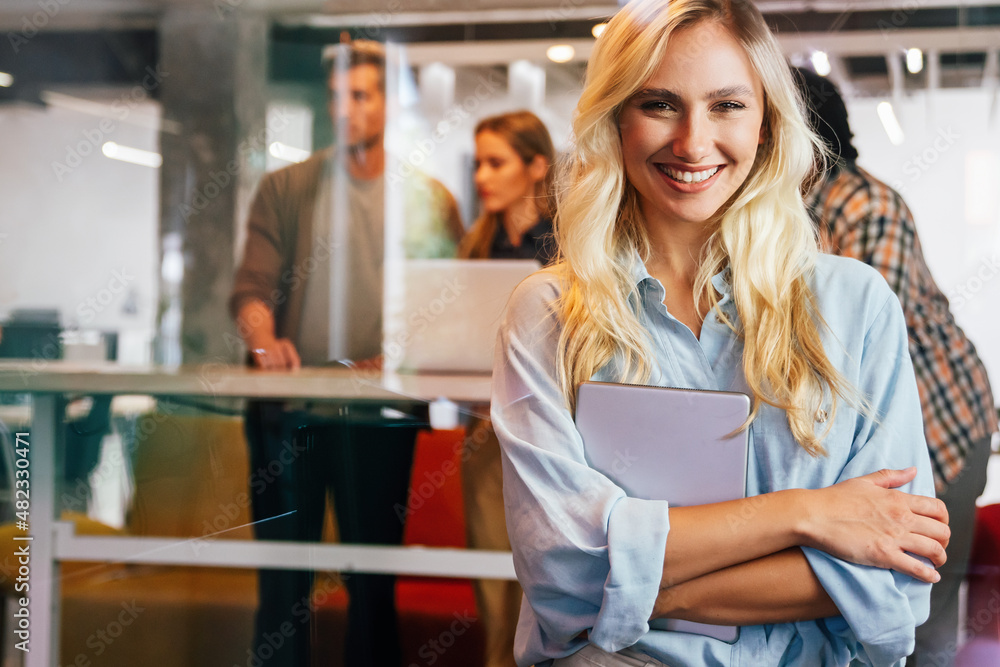 Portrait of an attractive young businesswoman smiling working on digital tablet in office