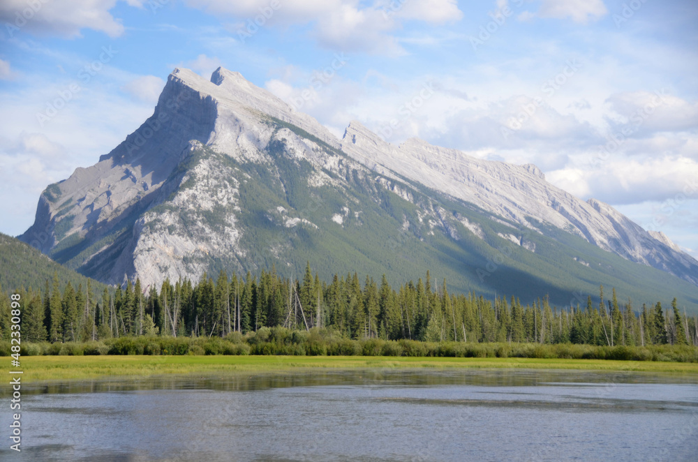 Landscape of lake with mountain range and pinetree forest in Canada