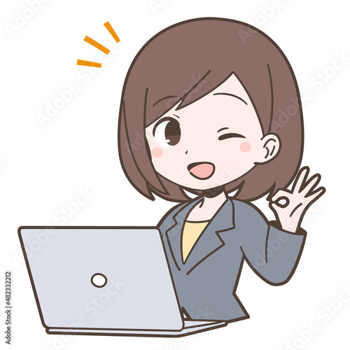 ビジネススーツ姿でPCの前でOKサインを出す若い女性