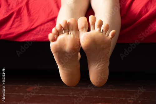 bare feet on the bed, the girl sleeps on the bed