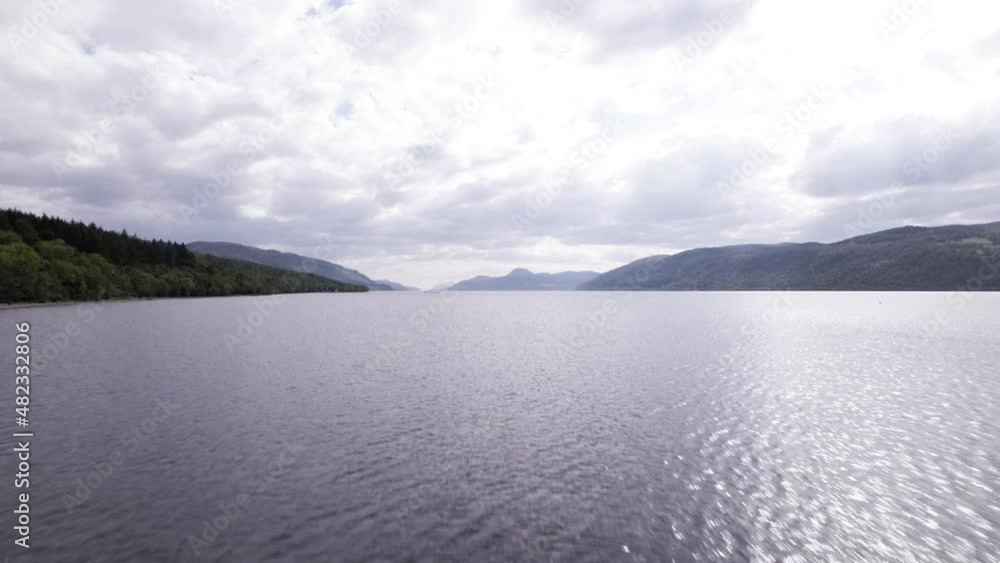 Aerial drone flying over open lake with mountains in background Aerial drone flying over open lake with mountains in background