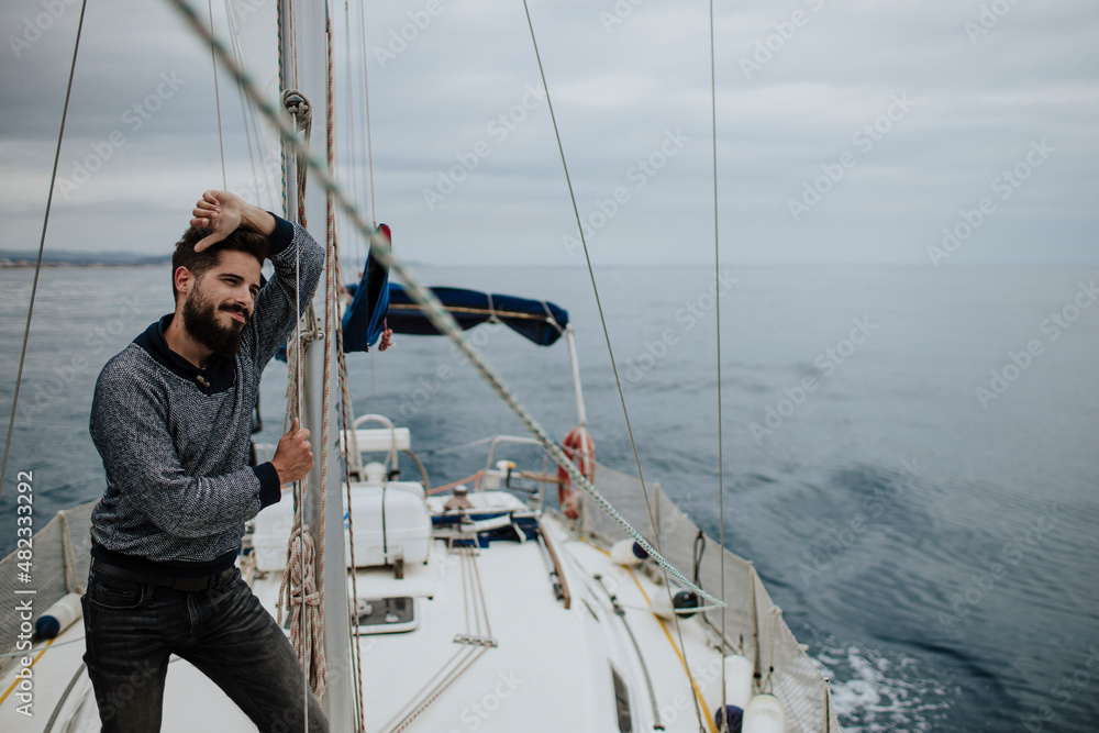 Thoughtful man leaning on mast of sailboat in Mediterranean Sea Thoughtful man leaning on mast of sailboat in Mediterranean Sea