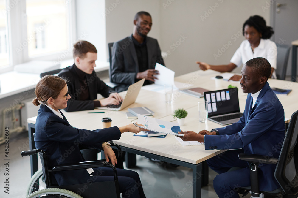 Side view portrait of businesswoman using wheelchair at business meeting in office, copy space Side view portrait of businesswoman using wheelchair at business meeting in office, copy space