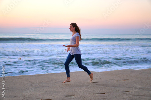 Play catch-up on the shore. Caucasian woman in jeans and a tank top plays on the sand. Beach fun on vacation. High quality photo