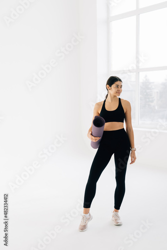 Fit woman with a gym mat isolated over white backgound © F8  \ Suport Ukraine