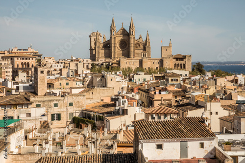 Spain, Balearic Islands, Palma de Mallorca, Old town houses with Palma Cathedral in background photo