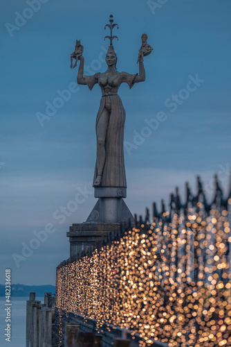 Germany, Baden-Wurttemberg, Konstanz, Statue of Imperia with Christmas lights in foreground photo