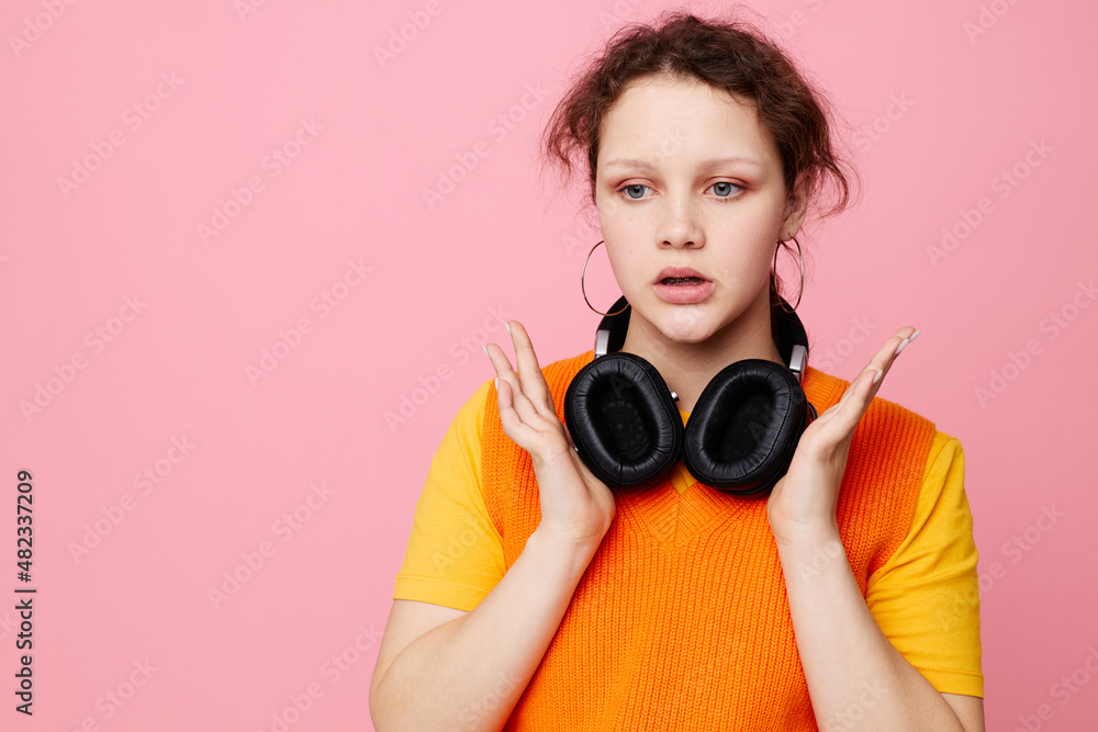 Obraz premium beautiful woman in an orange sweater headphones music entertainment pink background unaltered