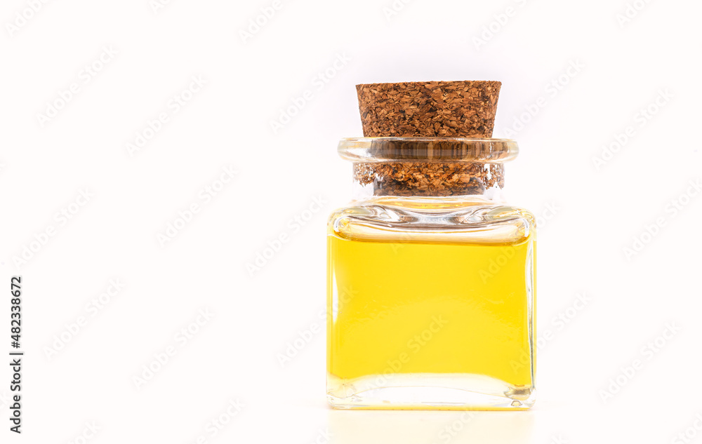 Spa essential oils in a cleared glass bottle with a cork, isolated image essential oils in a cleared glass bottle with a cork on white background. Short and square shape, front view with blank space. Spa essential oils in a cleared glass bottle with a cork, isolated image essential oils in a cleared glass bottle with a cork on white background. Short and square shape, front view with blank space.
