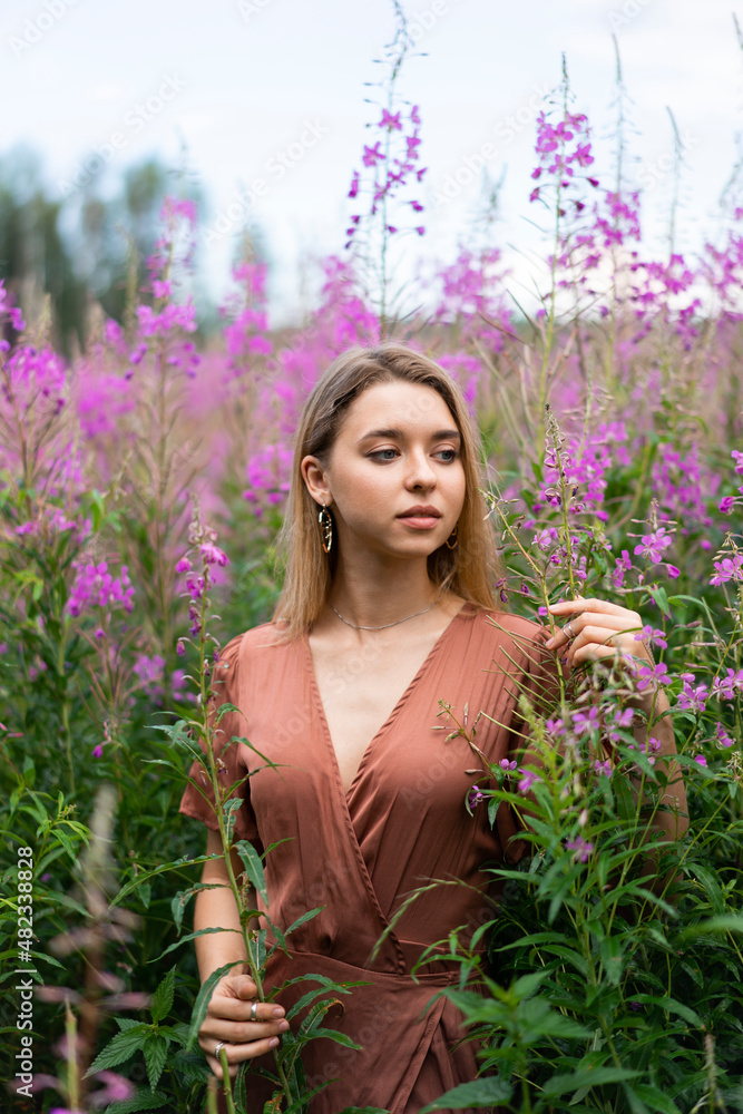 Thoughtful woman amidst flowering plants in meadow Thoughtful woman amidst flowering plants in meadow